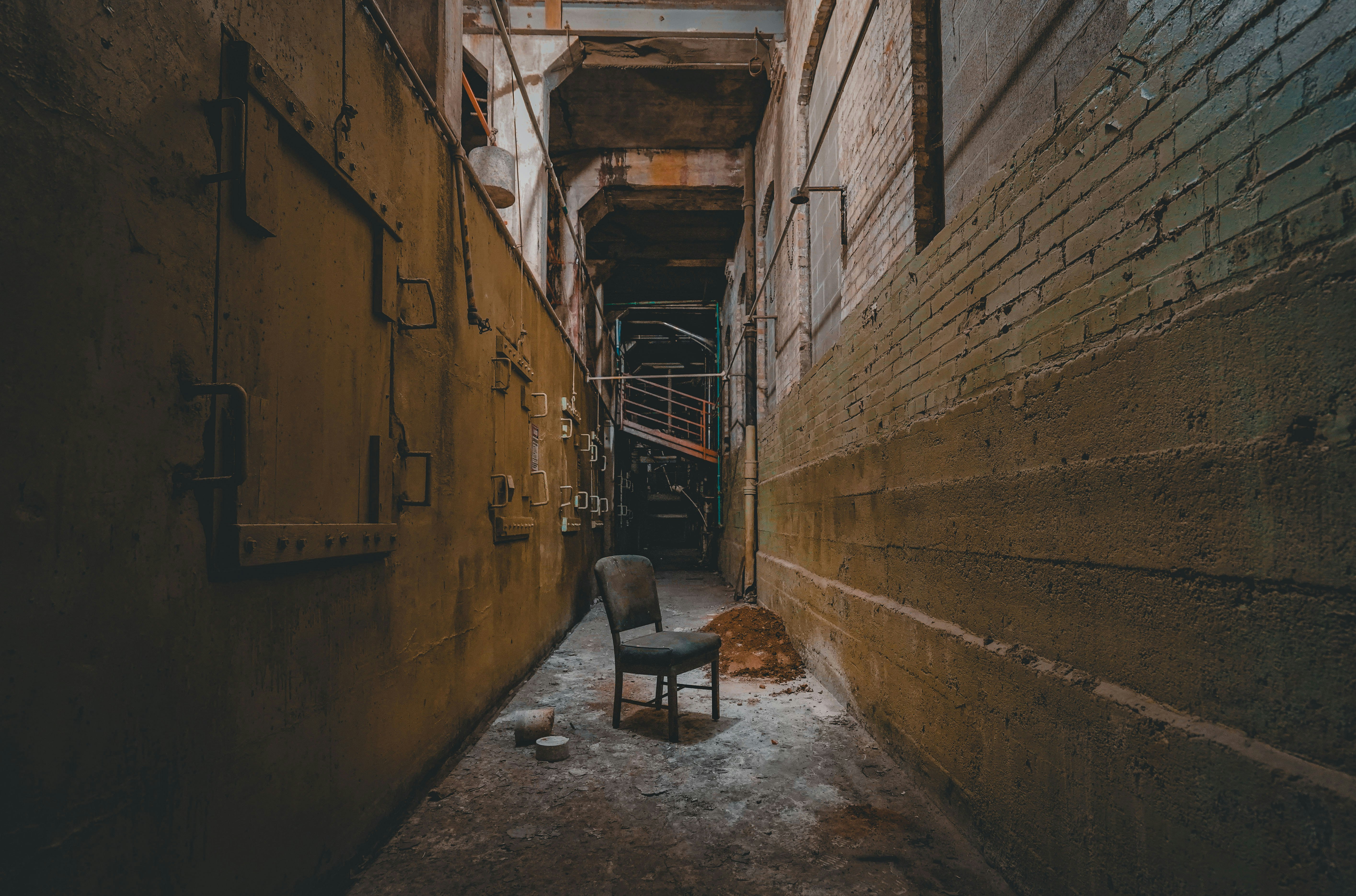 brown wooden chairs beside brown concrete wall